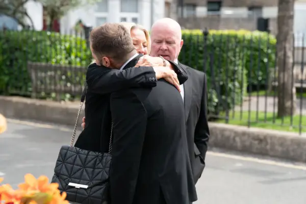 Kathy hugging Ben as Phil looks on in EastEnders