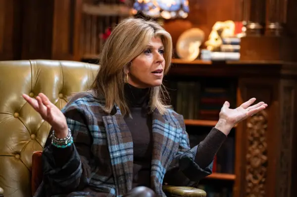 Kate Garraway sat down with her arms stretched out looking confused.