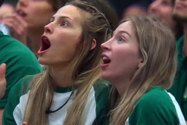 Two Squid Game: The Challenge players staring at the piggy bank in amazement.
