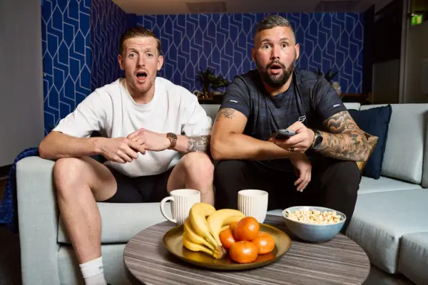 Jordan Pickford and Tony Bellew looking shocked as they look ahead, sat next to each other.