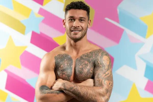 Love Island: All Stars contestant Callum shirtless posing in front of backdrop with colourful stars.