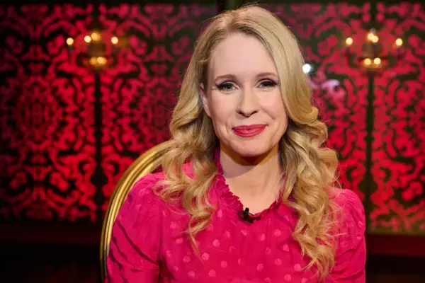 Lucy Beaumont in the Taskmaster studio, looking into the camera and smiling