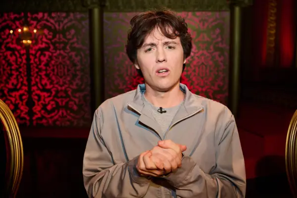 Sam Campbell on Taskmaster looking quizzically into the camera with his hands clasped together