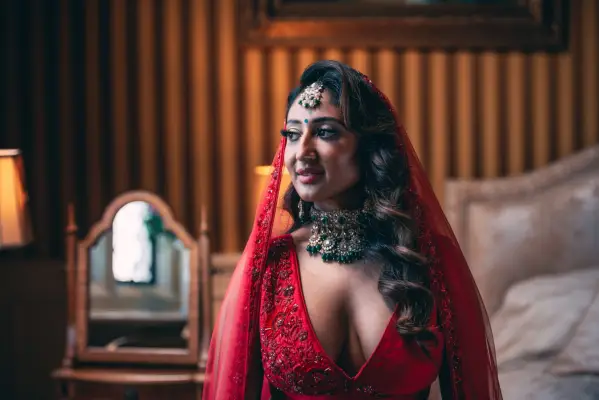 Nelly wearing a red traditional gown, looking to the side.