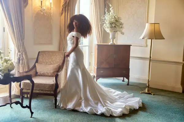 Julia-Ruth with her back turned to one side, looking ahead as she poses in a wedding dress.
