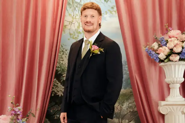 Leo wearing a black blazer, smiling ahead.