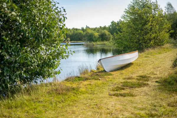 A boat in front of a lake on the grounds of The Traitors, Ardross Castle in the Scottish Highlands.