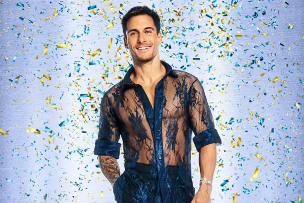 Gorka Márquez wearing a sheer lace blue shirt, smiling ahead.