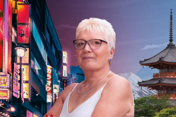 Pensioner with white hair and glasses looks at camera with scene of Japan behind her.