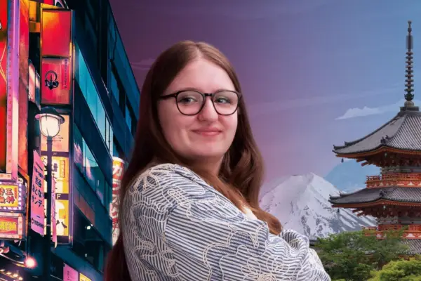 Woman with brown hair and glasses smiles at camera with scene of Japan behind her.