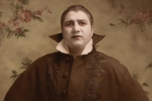 Nick Mohammed dressed as a vampire with his face painted white.