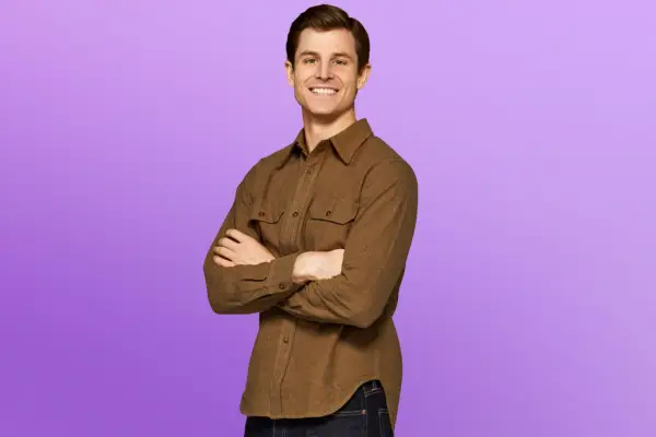 Blake wearing a light brown shirt, smiling ahead.
