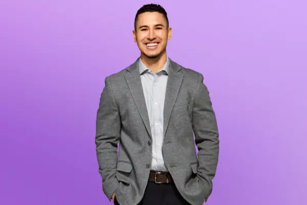 Brenden wearing a grey blazer and white shirt, smiling ahead.