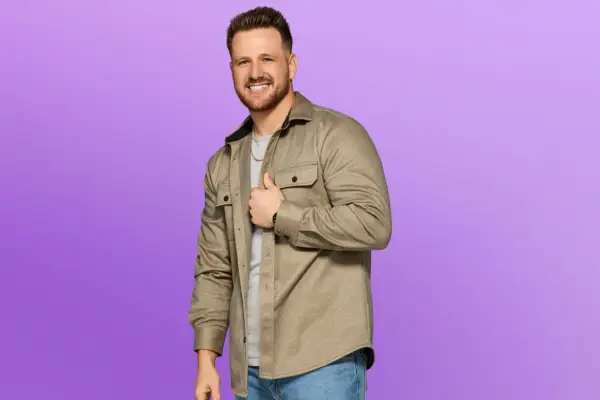 Dylan wearing a cream jacket, smiling ahead.