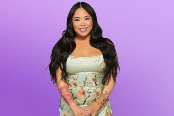 Anna wearing a green floral dress, smiling ahead.