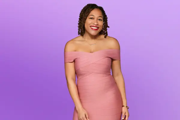 Ashley wearing a pink dress, smiling ahead.