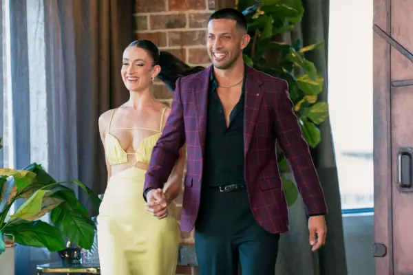 Beth and Teejay walking hand-in-hand, smiling widely.