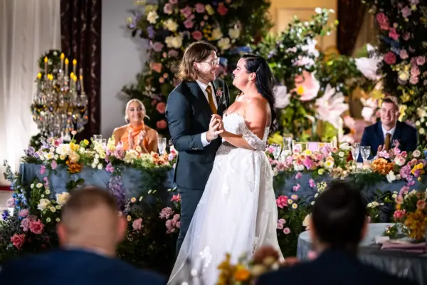 Ashleigh and Jake wearing wedding attire stood closely together as they dance.