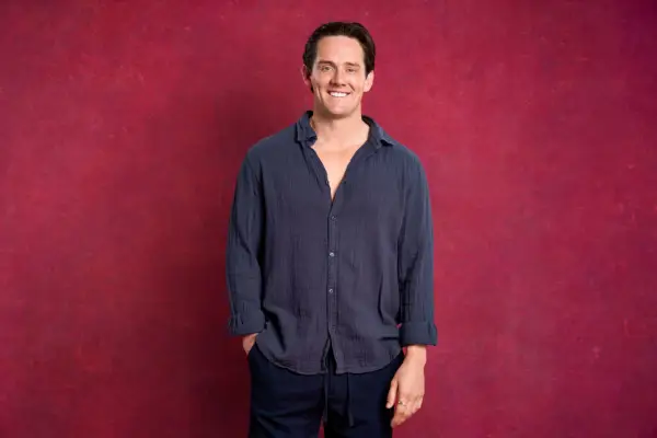 David wearing a blue shirt and trousers.