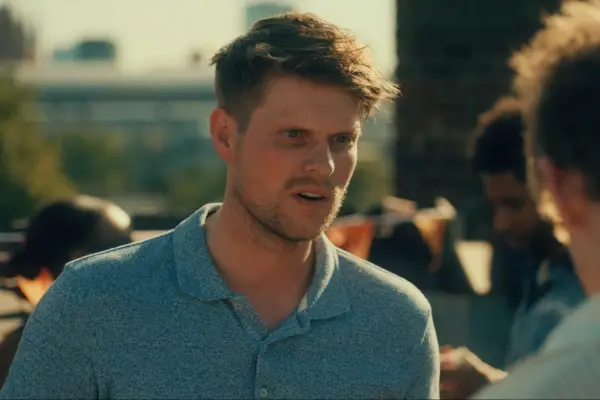 James Taylor looking shocked and confused at someone in front of him. He is wearing a light blue polo shirt.