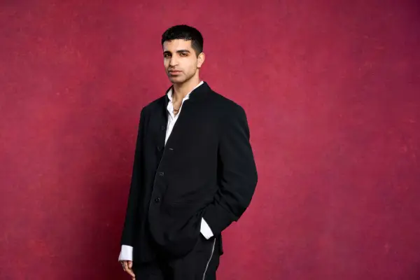 Kabir Khurana wearing a suit, looking ahead with one hand in his pocket.