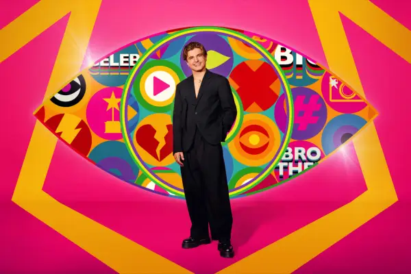 Strictly Come Dancing star Nikita Kuzmin wearing a black suit while posing in front of the iconic Big Brother eye for Celebrity Big Brother 2024.