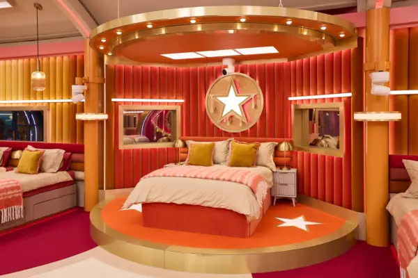 A double bed with stars all around it, with orange colouring.