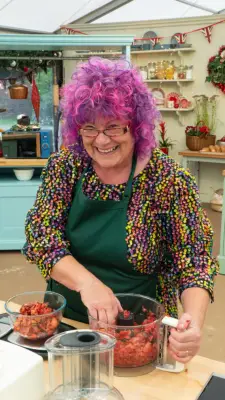 Carole wearing a multicoloured shirt and a green apron