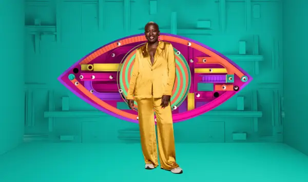 Feyisola wearing a satin yellow shirt and trousers, smiling ahead.