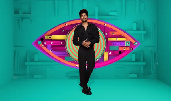 Gani wearing a black shirt and trousers, smiling ahead.