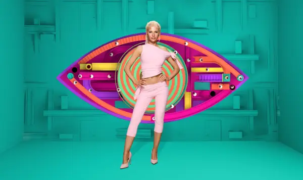 Elsa wearing a light pink top and capri trousers, looking ahead with her hands on her hips.