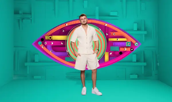 Tate wearing a white shirt and shorts, smiling ahead.