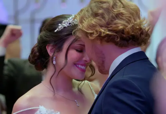 Amy and Johnny dancing together on their wedding night. She is leaning in close to him and smiling