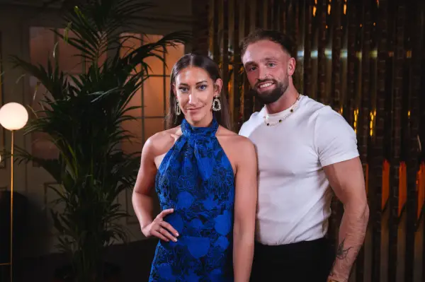 Hannah and Stephen smiling ahead, looking ahead as they stand next to each other.