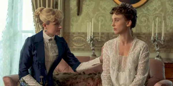Taissa Farmiga as Gladys sitting on the couch with Louisa Jacobson as Marian in The Gilded Age Season 3