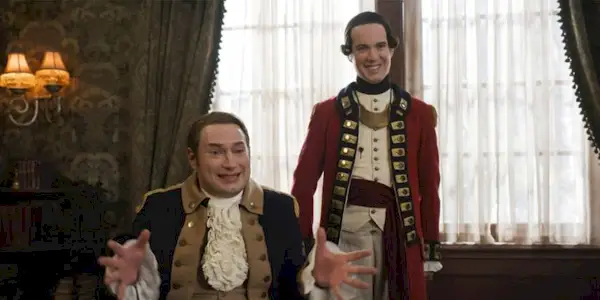 Isaac (Brandon Scott Jones) springs into an argument as Nigel (John Hartman) watches smiling in Ghosts Season 2