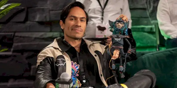 Horacio Garcia Rojas holding up a figure of Aztec Batman at SDCC 2025