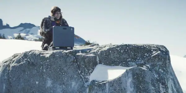 Sophie Thatcher as Natalie sitting on a snowy cliff speaking into a satellite phone in the Yellowjackets Season 3 finale
