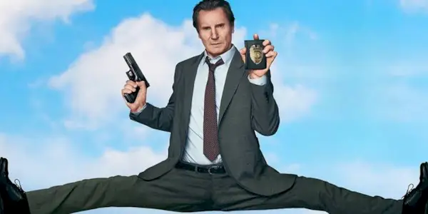 Liam Neeson as Frank Drebin Jr. in promotional image with legs spread across frame for The Naked Gun (2025).