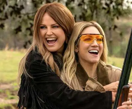 Margo and Sophie laughing together with a gun