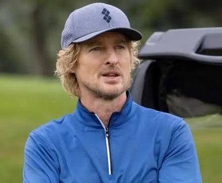 Owen Wilson leaning against a golfcart as Pryce Cahill in Stick.