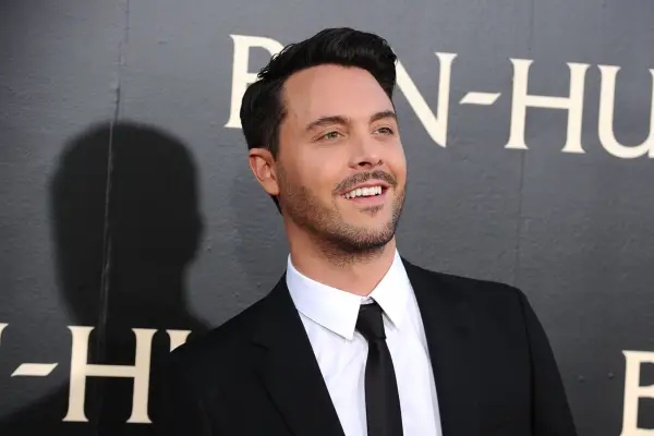 Jack Huston wearing a black suit