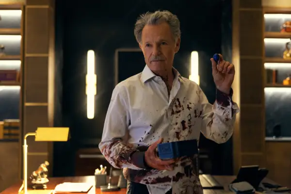 Bruce Greenwood stars in The Fall of the House of Usher, wearing a white and purple shirt, holding a box and a small spherical object
