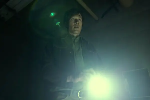 Zach Gilford as Roderick Usher in The Fall of the House of Usher holding a flashlight