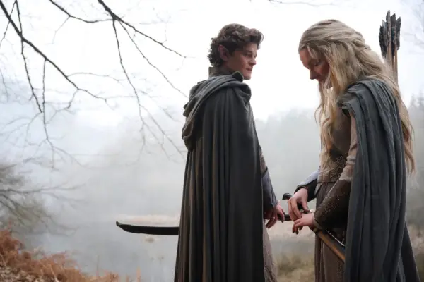 Robert Aramayo as Elrond and Morfydd Clark as Galadriel in The Rings of Power stood together in a foggy woodland
