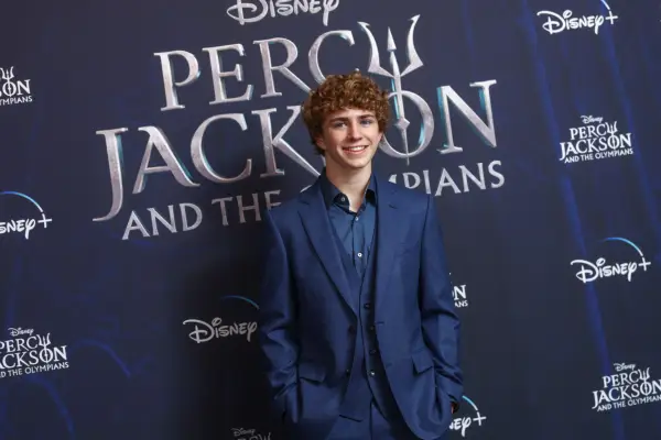 Walker Scobell wearing a navy suit on a red carpet