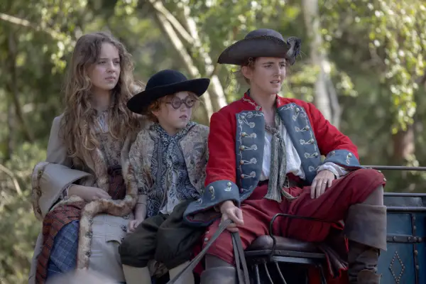 Bo Bragason as Roxy Trotter, Florence Keen as George Trotter and Louisa Harland as Nell Jackson in Renegade Nell, sitting on a carriage and looking forward