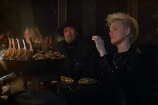 Odin and Loki sit at a banquet table in a scene from The Sandman season 2