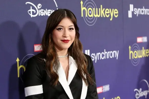 Alaqua Cox plays Maya Lopez / Echo in Hawkeye, standing on the red carpet in a black and white suit