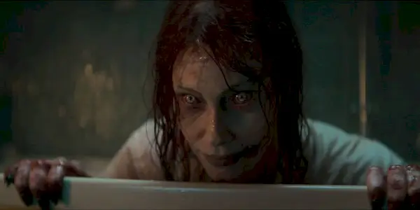 Alyssa Sutherland as Deadite Ellie crouched in a bathtub in Evil Dead Rise